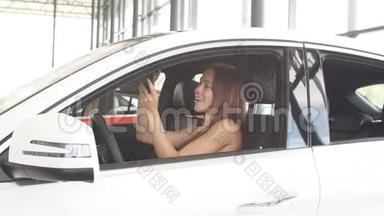 幸福的女司机在车展室的新车里拿着车钥匙